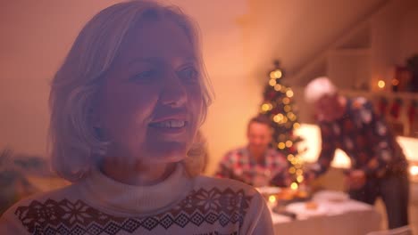 Grandmother-looks-out-the-window-Christmas-family-dinner-evening-behind-glass-cozy