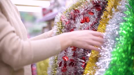 girl-chooses-Christmas-decorations-for-the-Christmas-tree-in-the-store