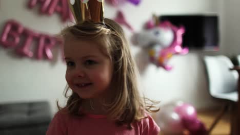 Blond-little-girl-on-birthday-as-a-princess.-Child-looks-surprised.-Unicorn