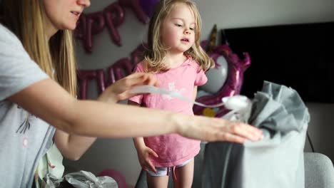 Blonde-kleine-Mädchen-öffnet-die-Geschenke.-Kind-schaut-in-die-Box,-ist-überrascht