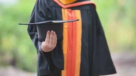 Asiatische-Studenten-trugen-am-Abschlusstag-schwarze-Rüschenanzüge,-schwarze-Hüte,-gelbe-Quasten.