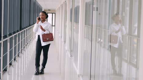 Young-dark-skinned-woman-with-a-bag-is-talking-on-the-phone