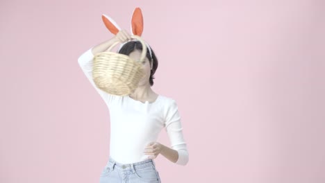 Cheerful-happy-girl-wear-bunny-ears,-hold-a-basket-with-Easter-eggs-colorful-joyful,-spinning-around-and-show-basket-forward-to-camera.-Funny-bunny-girl-in-Easter.The-symbolic-of-Easter-egg-festival.