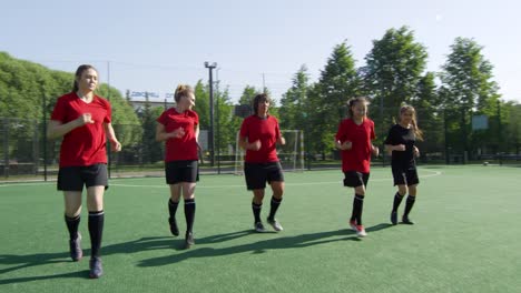 Weibliche-Fußballsportlerlaufen-rückwärts-auf-dem-Feld