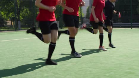 Atletas-de-fútbol-femeninohaciendo-levantamiento-de-talón-corriendo