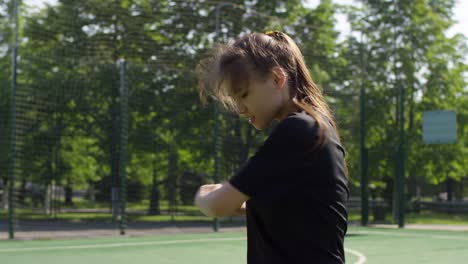 Chica-joven-haciendo-ejercicio-de-estiramiento-antes-de-entrenamiento-de-fútbol