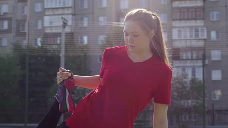 Joven-jugadora-de-fútbol-femenino-haciendo-de-pie-Quad-Stretch