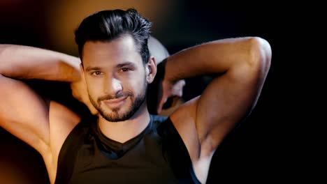 Sportsman-with-ball-smiling-and-looking-at-camera-on-dark-background