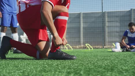 Fußballer-binden-seine-Schuhe-auf-dem-Feld