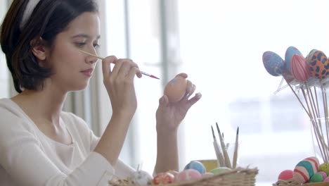 Portrait-of-cheerful-happy-girl,-paint-on-fantasy-easter-eggs-with-a-brush-beautiful-decorative-and-colourful-of-handmade-attentively.-Holidays-and-people-the-symbolic-of-Easter-egg-festival-concept.