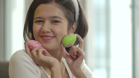 Cheerful-happy-girl,-paint-on-fantasy-easter-eggs-with-a-brush-beautiful-decorative-of-handmade,-show-colourful-of-the-eggs-at-camera.-Holidays-and-people-the-symbolic-of-Easter-egg-festival-concept.