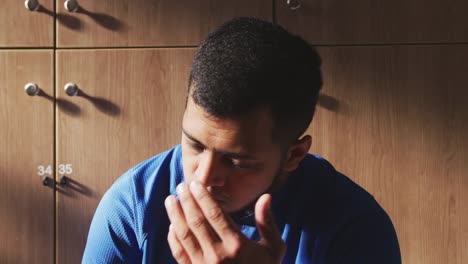 Concentrated-soccer-player-in-the-locker-room