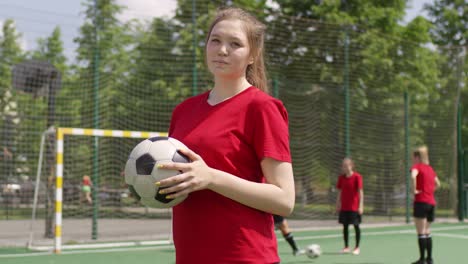 Junge-Sportlerin-Jonglieren-Fußball-und-posiert-für-Kamera