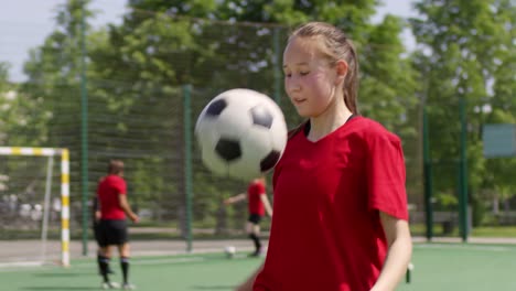 Soccer-Girl-Juggling-a-Ball-on-Playing-Field