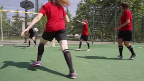 Junge-Frauen,-die-auf-green-field-Fußball-spielen