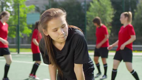 Müde-Teenage-Girl-Machen-Pause-während-Fußball-Training