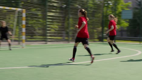 Junge-Mädchen,-die-ImStadion-Fußball-spielen