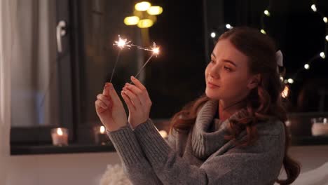 glückliche-junge-Frau-mit-Wunderkerzen-zu-Hause