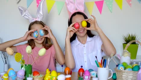 Mother-and-her-little-daughter-painting-eggs.-Happy-family-preparing-for-Easter.