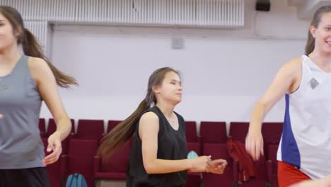 Equipo-de-baloncesto-femenino-haciendo-acumulación-de-manos-antes-de-comenzar-un-juego