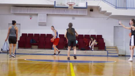 Jóvenes-Atletas-Femeninas-Practicando-Disparar-Baloncesto-en-El-Aro