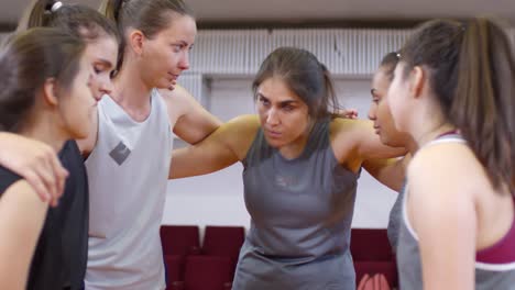 Jugadoras-de-Baloncesto-Femeninas-apiñadas-y-teniendo-charlas-inspiradoras