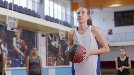 Professionelle-Sportlerin-schießt-einen-Basketball-mit-Unterstützung-des-Teams