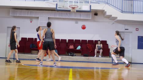 Professionelle-Spielerinnen-üben-Schießen-Basketball-in-Reifen