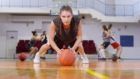 Joven-atleta-femenina-haciendo-flexiones-con-baloncesto