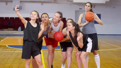 Equipo-de-baloncesto-joven-femenino-tomando-selfie-con-Smartphone