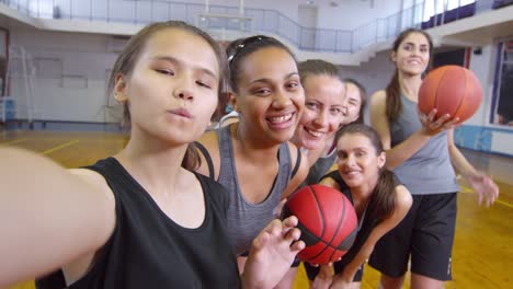 POV-de-las-jugadoras-de-baloncesto-femeninas-sonriendo-a-la-cámara-y-posando-para-selfie