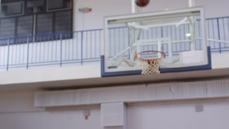 Sportlerin-schießt-einen-Basketball-auf-Indoor-Court