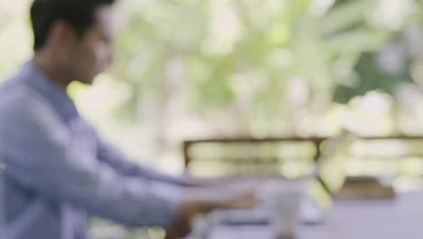 Pull-focus-shot-of-man-typing-on-laptop.