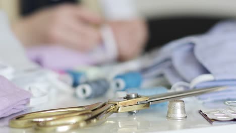 Close-up-of-female-hands-sew-medical-masks.-Seamstress.-Scissors.