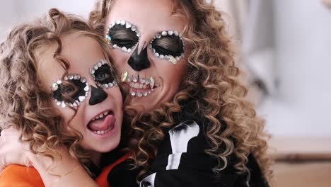 Portrait-of-mother-and-daughter-with-curly-hair-wearing-costumes