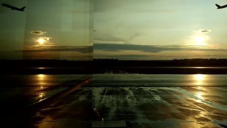 Reflexión-en-la-ventana-del-aeropuerto-de-un-avión-de-despegue-durante-la-puesta-del-sol