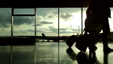 Silhouettes-of-passengers-at-the-airport-during-sunset