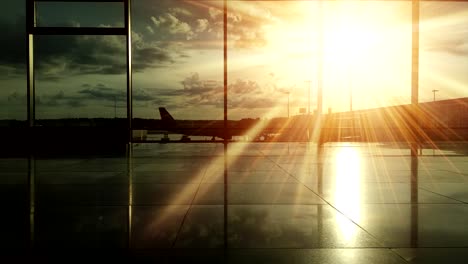 Silhouetten-der-Passagiere-am-Flughafen-bei-Sonnenuntergang