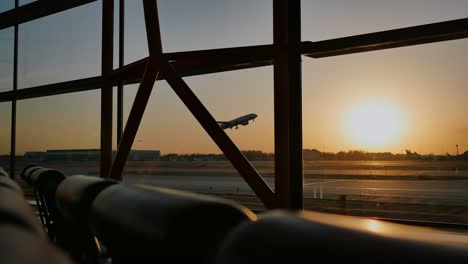 Silueta-de-un-avión-despegando-al-atardecer-en-el-aeropuerto-de-Pekín-en-el-fondo-de-una-ventana