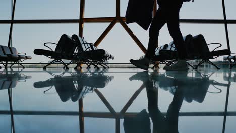 Silhouette-Gruppe-von-Passagieren-zu-Fuß-mit-Gepäck-am-Flughafen