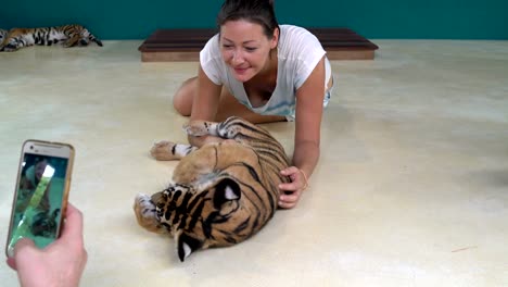 Men's-hand-in-photographing-a-woman-with-Tiger-Cub