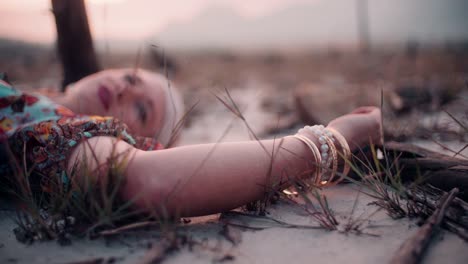 Boho-girl-lying-on-the-ground-in-vintage-floral-dress