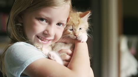 Una-niña-pequeña-y-sonriente-sosteniendo-un-mascota