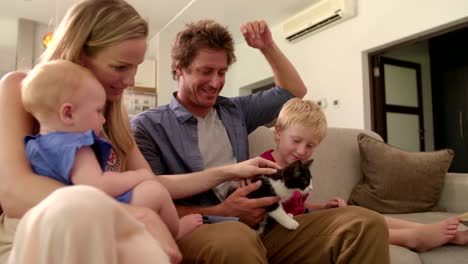 Family-of-Four-Sitting-Together-on-Couch-in-Living-Room-with-a-kitten