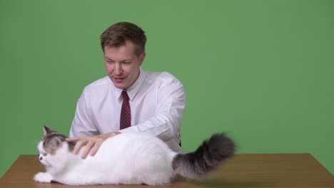 Young-handsome-Scandinavian-businessman-against-green-background