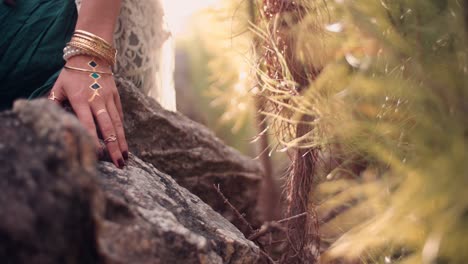 Woman's-hand-with-boho-style-jewellery-in-nature