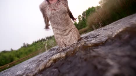 Hippie-girl-standing-in-a-lake-splashing-water