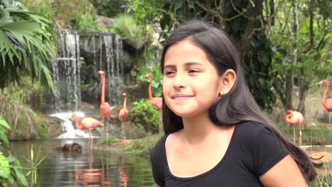 Mädchen-in-der-Nähe-von-Wasserfall-und-Flamingos