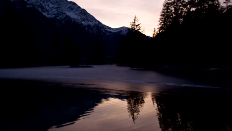 Frozen-lake-near-Mont-Blanc-and-ducks,-sunset,-slowmotion