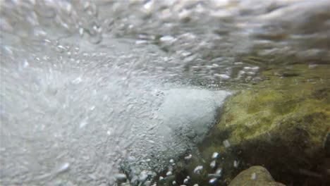 Vista-interior-de-un-río-con-burbujas-grandes-de-piedra-y-el-agua-pasa